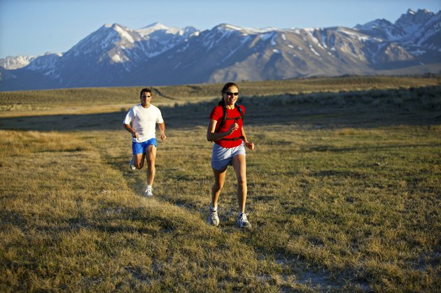 Man and woman running with mountains, California, USA