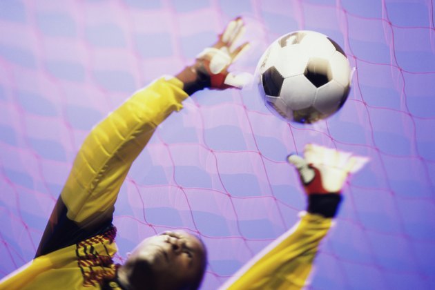 Low angle view of a goalie catching a ball