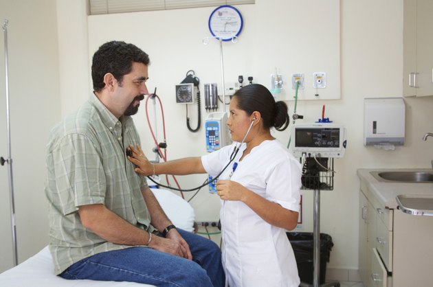 Female nurse examining a patient with a stethoscope