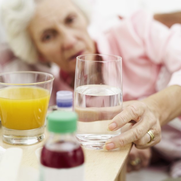senior woman reaching out for a glass of water