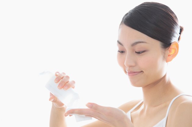 Woman pouring lotion in hand