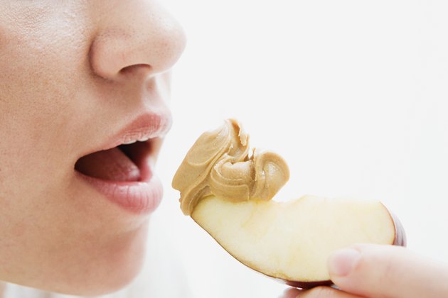 Woman eating apple and peanut butter