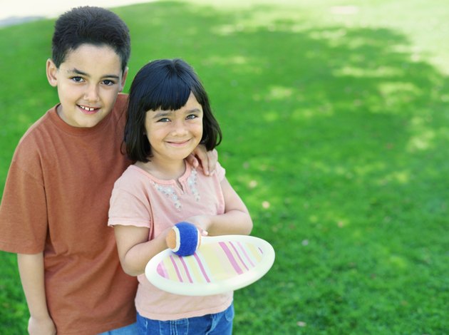 high angle view of a brother and his sister standing in a park