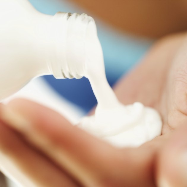 close-up of woman pouring lotion into her hand