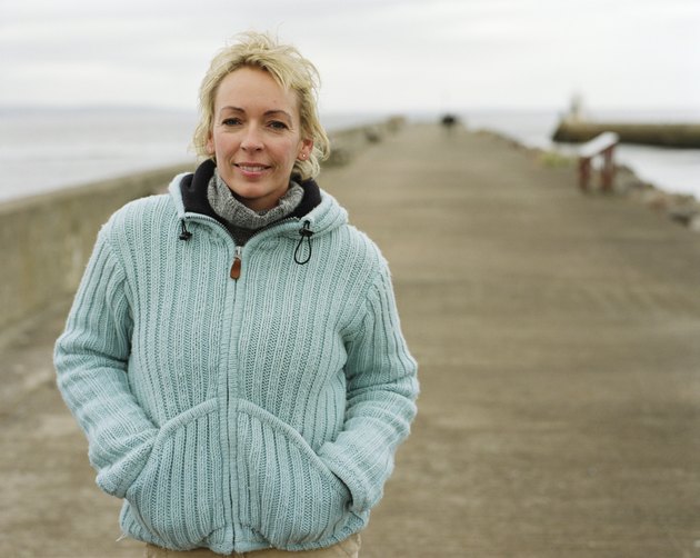 Mature woman outdoors by sea, smiling, portrait