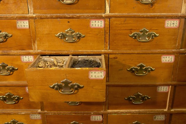Cabinet in Chinese herb store, drawer open revealing herbs