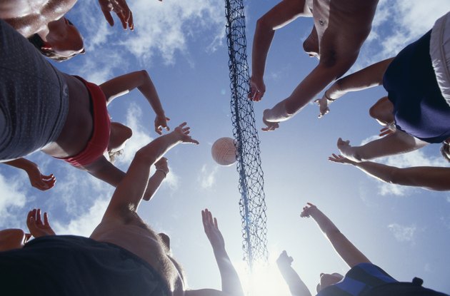 Young people playing volleyball, view from below