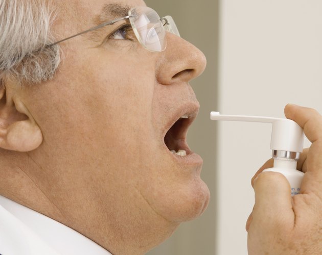Mature man using mouth spray, close-up