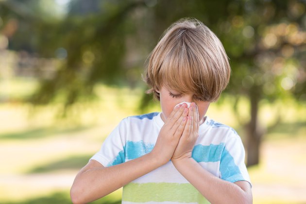 Little boy blowing his nose