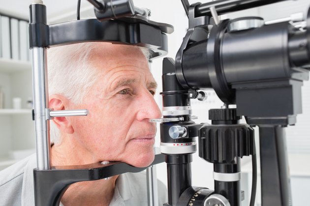Man looking into slit lamp