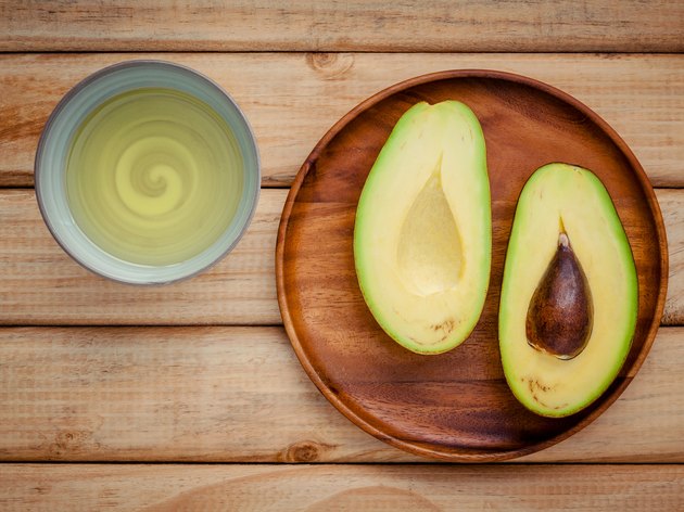 Fresh avocado and oil on wooden background. Organic avocado heal