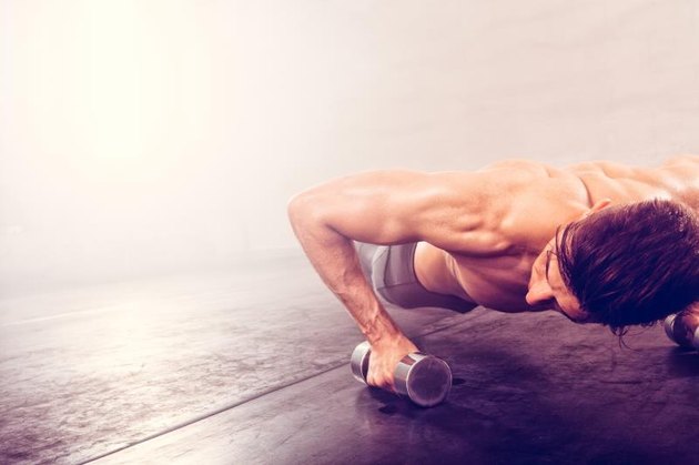 Man doing push-up exercise with dumbbell