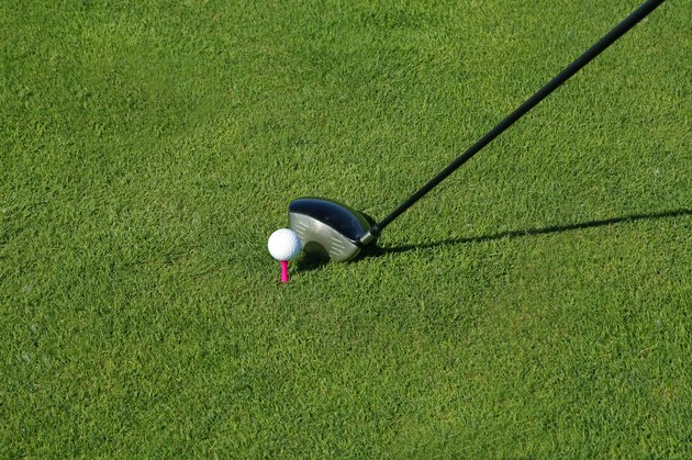 Golf club and ball in grass