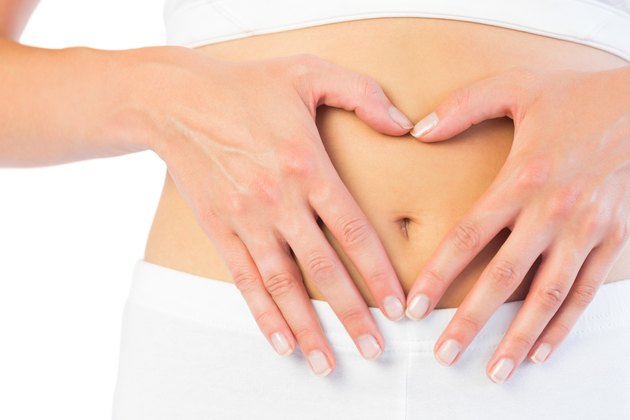 Close up picture of fit woman holding her belly