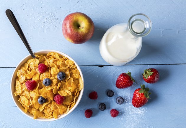 Cornflakes in a bowl with milk and fruits