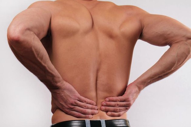 Close up of man holding his lower back. Man rubbing his painful back. Pain relief concept
