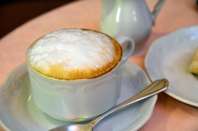 Delicious cappuccino on a white cup on a table