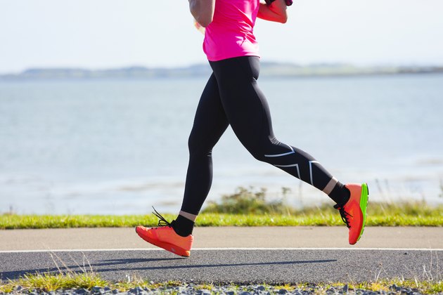 Woman compete in the marathon race on coastal road