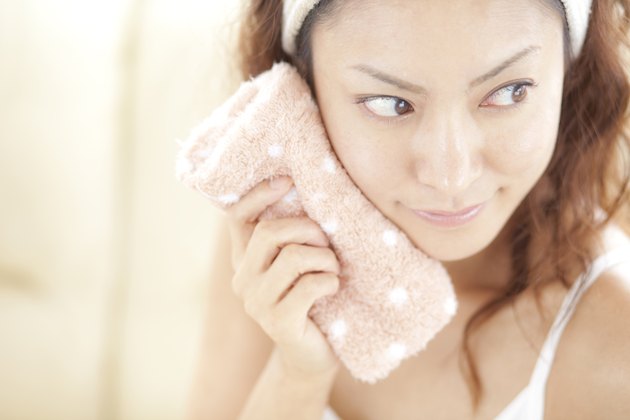 Young woman drying face, close up