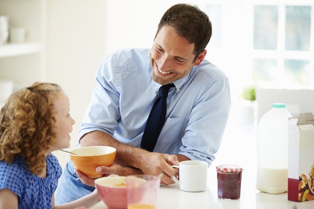 Father And Daughter Having Breakfast In Kitchen Together