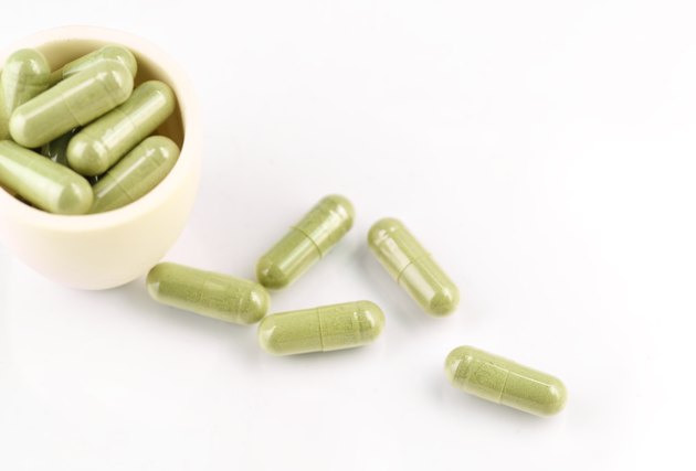 herb capsules on white background