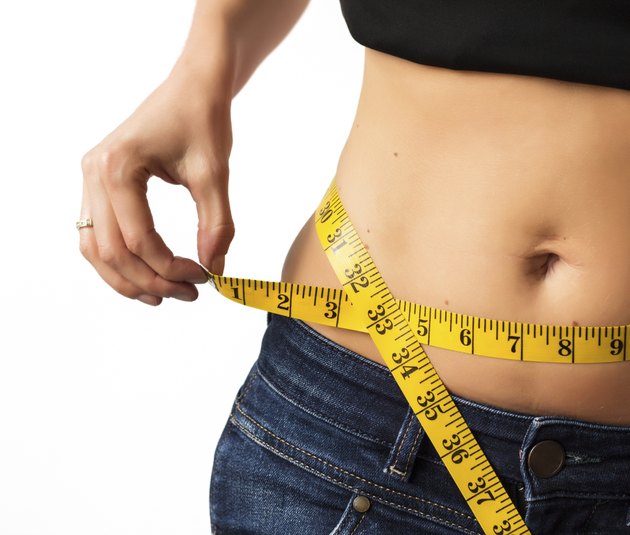 Woman measuring her waistline