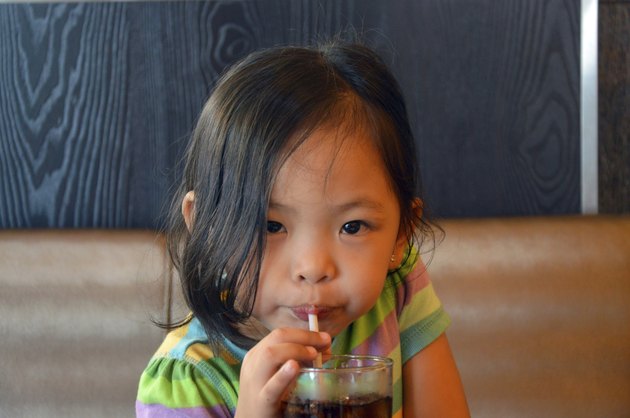child sipping soda