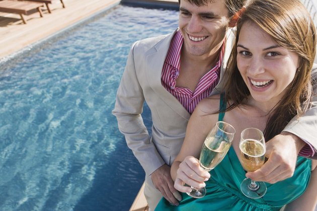 Couple with champagne poolside