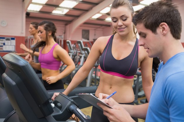 Trainer helping a woman in a gym