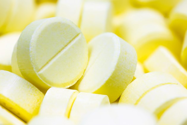 Heap of yellow round medicine tablet antibiotic pills. Shallow DOF