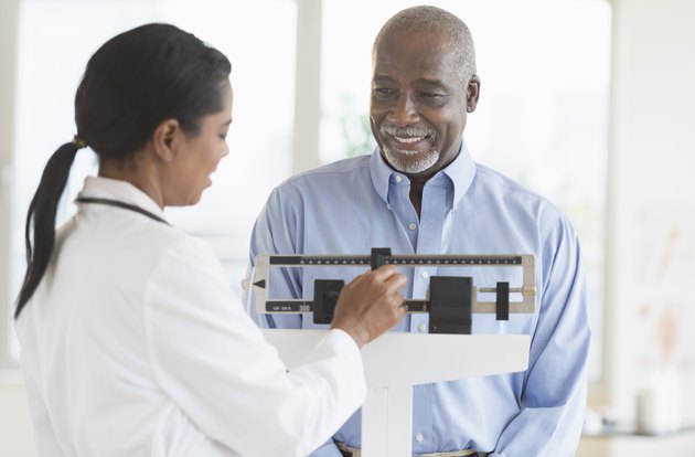 Black doctor weighing patient