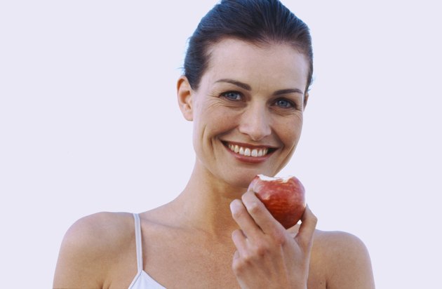 Portrait of a young woman holding an apple smiling