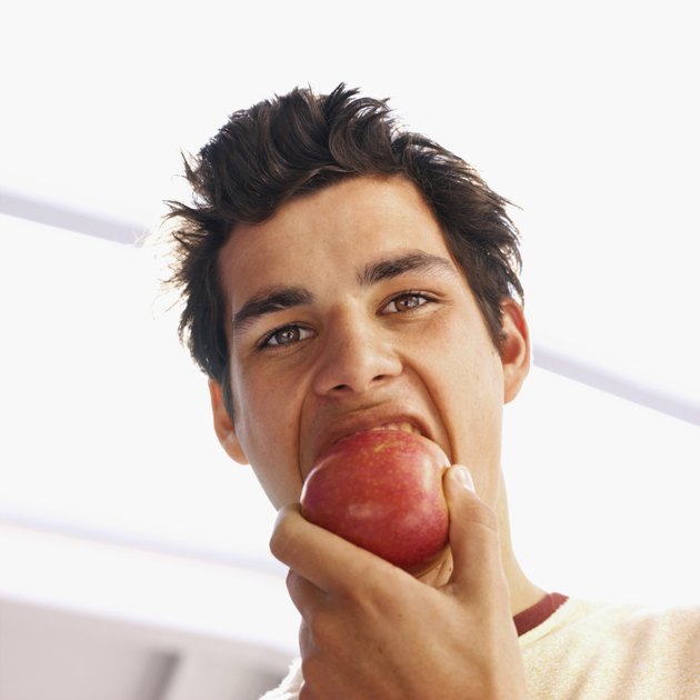 Close-up of young man eating apple