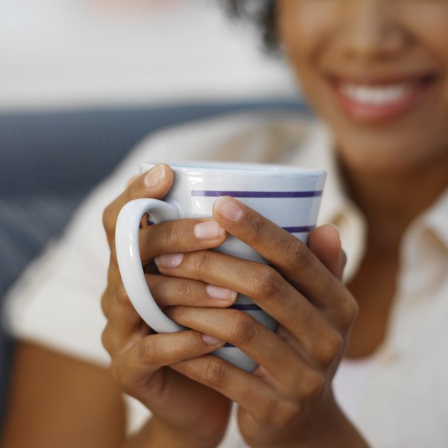 Close-up of young woman holding mug of coffee