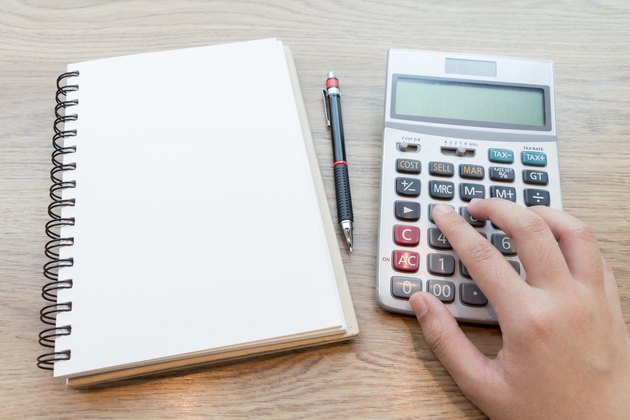 Hands of business woman working with calculator.