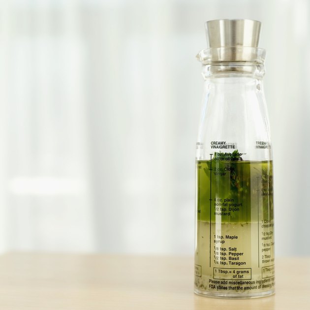 Close-up of a bottle of herbs in olive oil