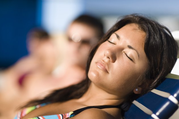 Woman sunbathing by swimming pool
