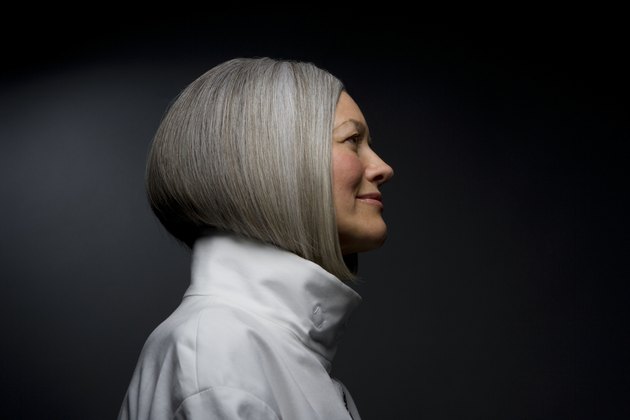 Mature woman smiling, side view, close-up