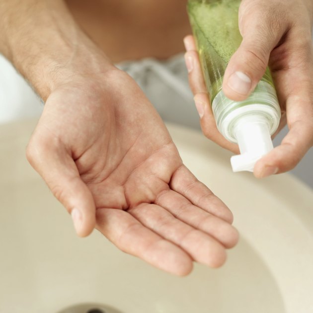 Close-up of a young man holding a bottle of aftershave