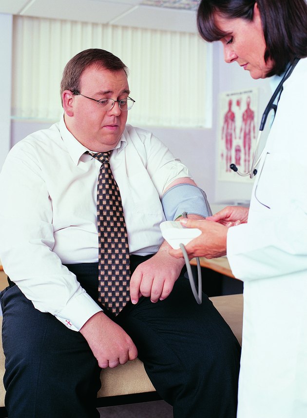 Overweight Businessman Having his Blood Pressure Taken by a Doctor