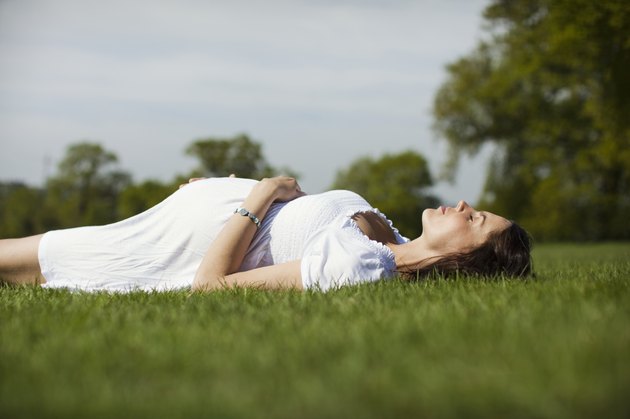 Pregnant woman lying on grass