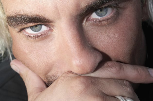 Close up of Hispanic man with hand on face