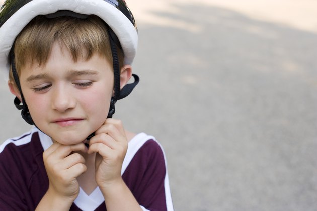 Boy adjusting helmet