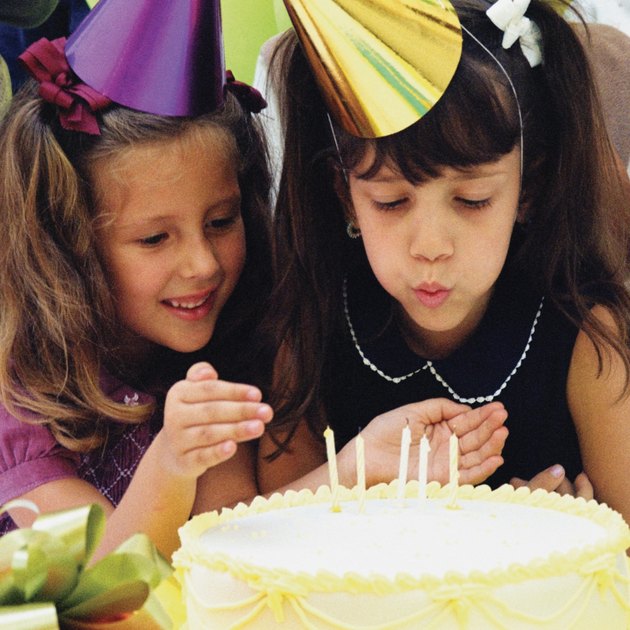 Two girls wearing birthday party hats