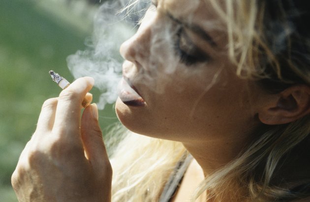Young woman smoking cigarette, close-up