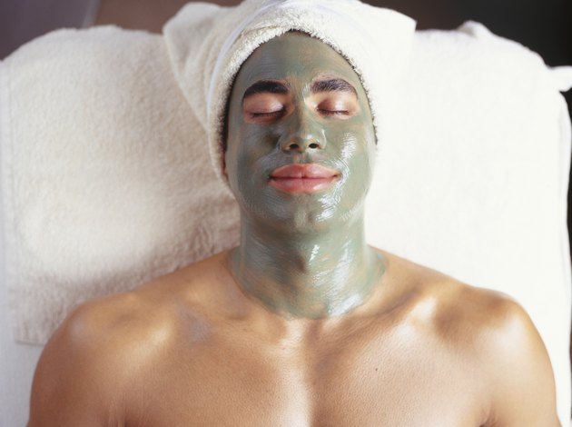 Young man with facial mask at beauty parlour, (overhead view