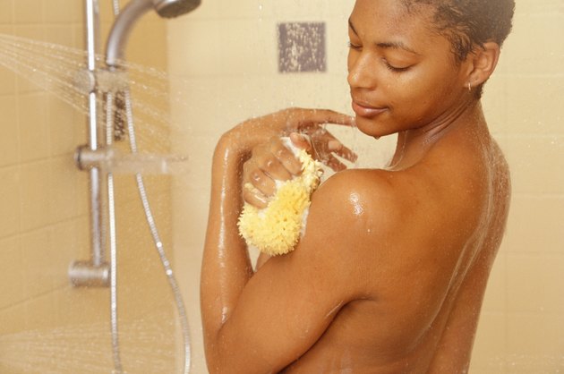 Woman showering at home, close-up