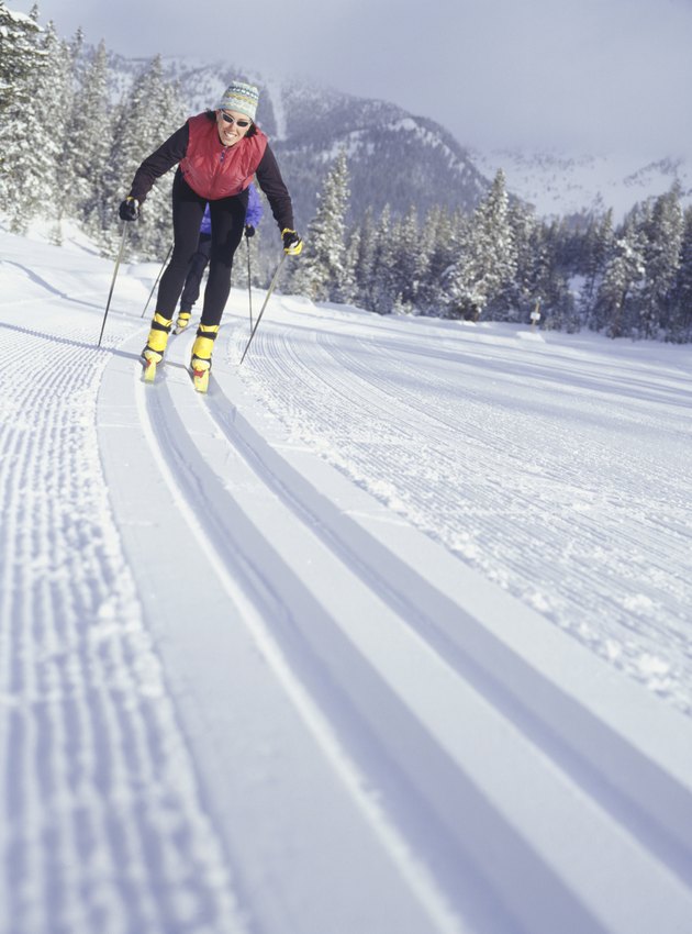 Two people skiing down track in snow