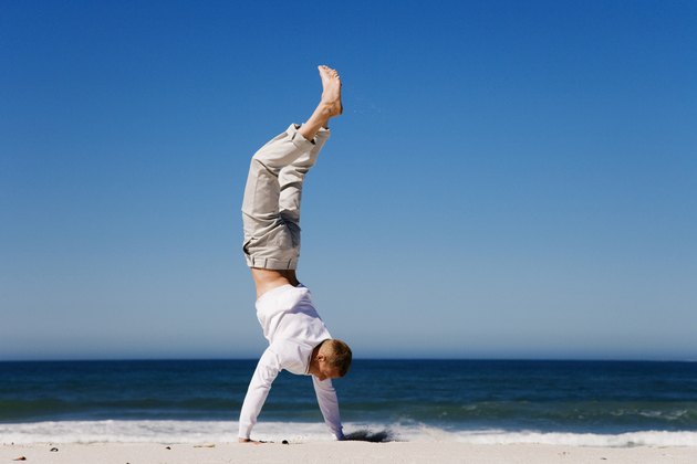 Man doing handstand on beach