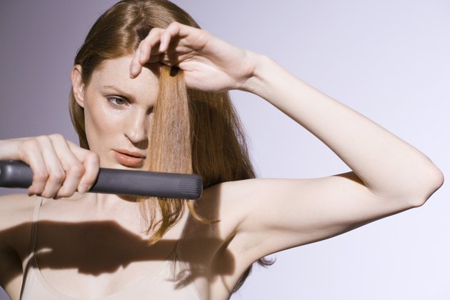 Woman using straight-iron on her hair